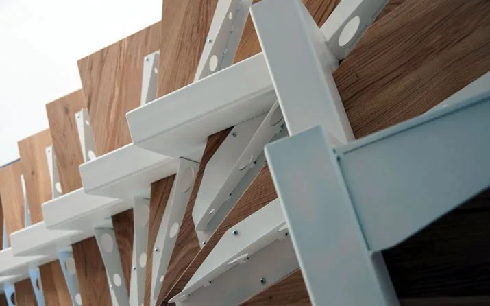 Stiege mit weißen Stahlträgern und Holzstufen, von unten gesehen