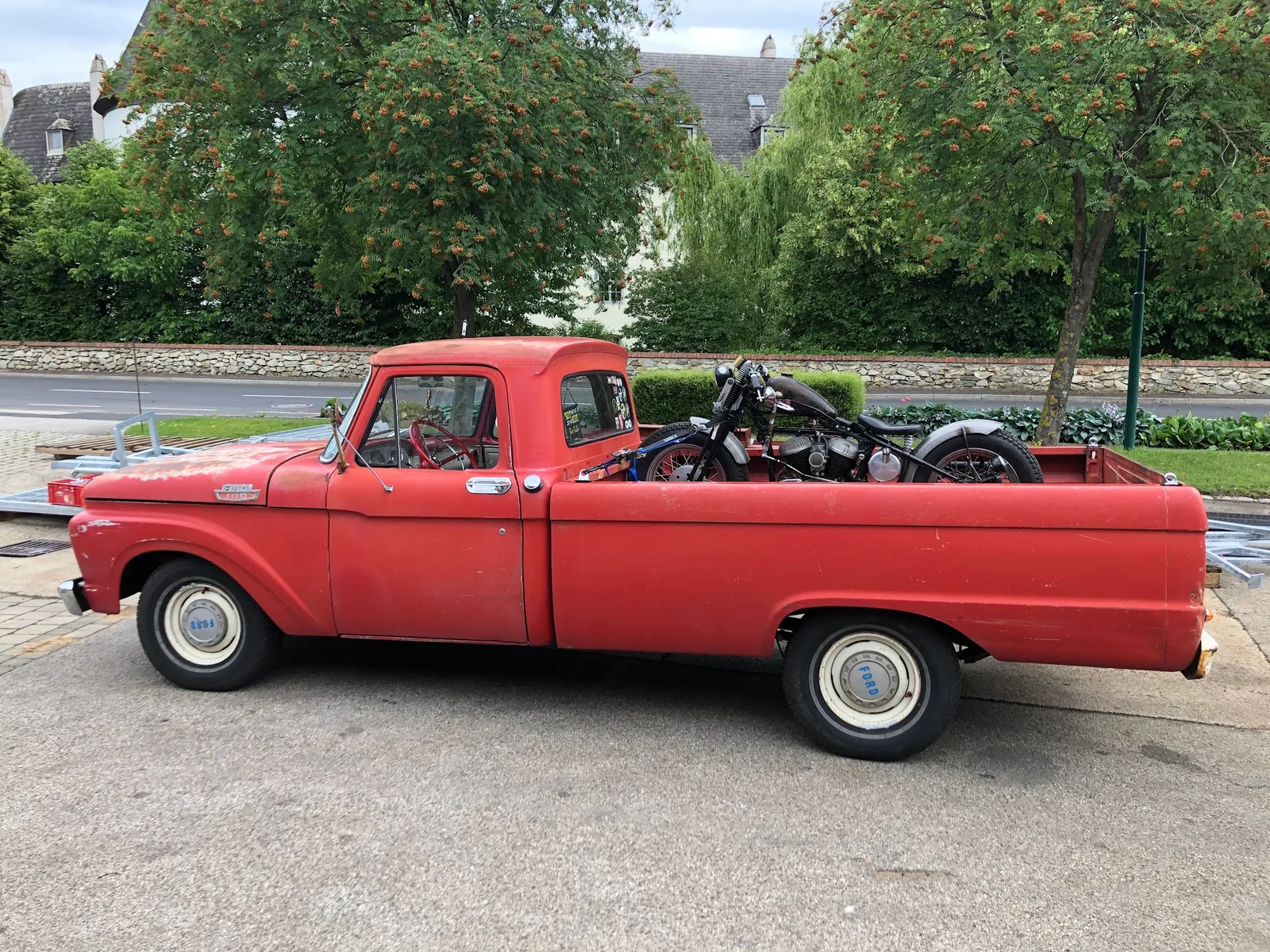 Roter Ford Pick-up, auf der Ladefläche zwei Motorräder